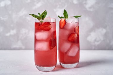 Buzlu taze çilekli limonata ve masada nane şekeri, kopyalama alanı. Soğuk yaz içkisi. Meyve kokteyli ve köpüklü bardak.