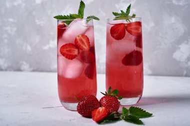 Buzlu taze çilekli limonata ve masada nane şekeri, kopyalama alanı. Soğuk yaz içkisi. Meyve kokteyli ve köpüklü bardak.
