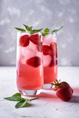 Buzlu taze çilekli limonata ve masada nane şekeri, kopyalama alanı. Soğuk yaz içkisi. Meyve kokteyli ve köpüklü bardak.