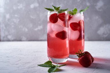 Buzlu taze çilekli limonata ve masada nane şekeri, kopyalama alanı. Soğuk yaz içkisi. Meyve kokteyli ve köpüklü bardak.