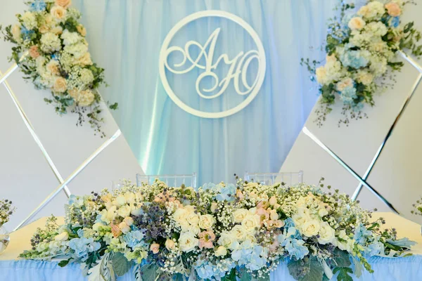 Lush floral arrangement. Luxury wedding decorations. Wedding presidium in restaurant, copy space. Banquet table for newlyweds with blue, pink, beige flowers and greenery