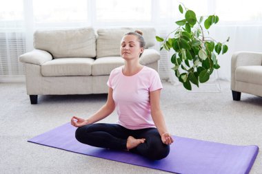 Lotus pozisyonda oturan ve, meditasyon kız iç ev, uzay kopyalayın. Padmasana. Kadın evde yoga uygulamak. El jest meditasyon içinde kapatın. Özgürlük kavramı