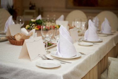 Masada boş misafir kartı, tabakta peçete ve çatal bıçak takımı, kopyalama alanı. Düğün resepsiyonunda. Restoranda düğün yemeği için servis edilen masa.