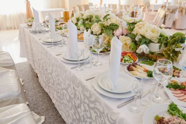 Tabaklar, beyaz peçeteler ve çatal bıçak seti, kopyalama alanı. Düğün resepsiyonunda. Restoranda düğün yemeği için servis edilen masa.