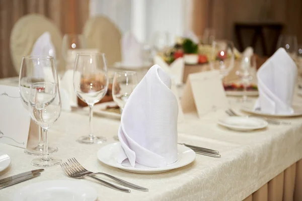 テーブルには空白のゲストカード テーブルにはサービットとカトラリー付きのプレート コピースペースが設定されています 結婚式のレセプションでの場所設定 レストランでの結婚式の宴会のテーブル — ストック写真