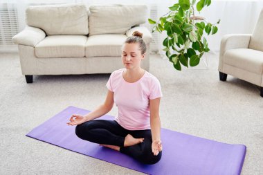 Lotus pozisyonda oturan ve, meditasyon kız iç ev, uzay kopyalayın. Padmasana. Kadın evde yoga uygulamak. El jest meditasyon içinde kapatın. Özgürlük kavramı