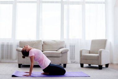 Pratik yoga adlı genç bir kadın portresi kapalı ev, uzay kopyalayın. Mat, tam uzunlukta germe kız. Rahatlatıcı ve yoga yapıyordum. Sağlık ve sağlıklı yaşam tarzı
