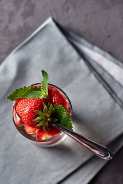 Çilekli su ve nane şekerli bardaklar beton masada gri peçete, kopyalama alanı. Soğuk yaz içkisi. Maden suyu.