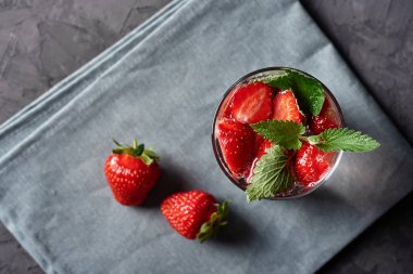 Çilekli su ve nane şekerli bardaklar beton masada gri peçete, kopyalama alanı. Soğuk yaz içkisi. Maden suyu.