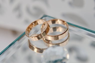 Aynalı cam kutuda iki altın alyans, kopyalama alanı. Düğün kartı.