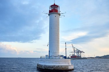 Gün batımında denizdeki kırmızı ve beyaz deniz feneri, kopyala uzayı. Deniz manzarası ve deniz feneri. Karadeniz