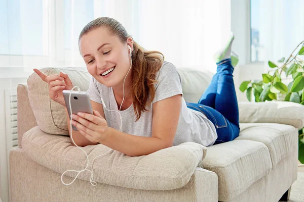 Mujer Escuchando Música Auriculares Mientras Está Acostada Sofá Habitación Casa — Foto de Stock