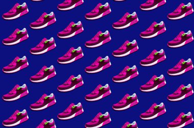 Parlak mavi arka planda pembe spor ayakkabılarla yapılan renkli desenler. Asgari, güzellik ve moda konsepti.