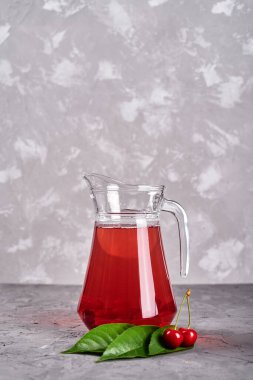 Gri masa arka planında taze vişneli limonata, kopyalama alanı. Soğuk yaz içkisi. Meyve kokteyli.