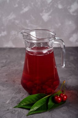 Gri masa arka planında taze vişneli limonata, kopyalama alanı. Soğuk yaz içkisi. Meyve kokteyli.