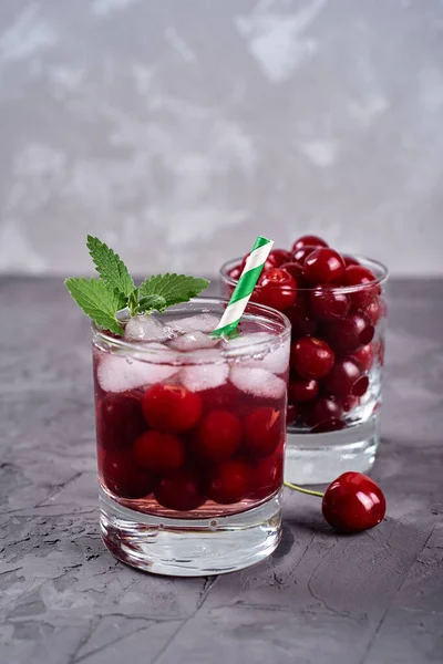 灰色のテーブルの背景に輝くガラスで氷 ミントと紙のわらで新鮮なチェリーレモネード コピースペース 冷たい夏の飲み物 ベリーカクテル — ストック写真