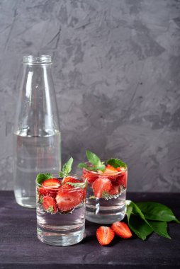 Çilekli su ve ahşap masa zemininde köpüklü bardaklarda nane şekeri, kopyalama alanı. Soğuk yaz içkisi. Maden suyu.