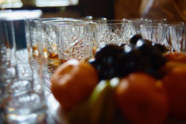 Restorandaki yemek masasında köpüklü cam ve meyveler, fotokopi odası. Kristal bardaklar kutlamaya hazır. Lüks düğün resepsiyonunda şarap kadehleri