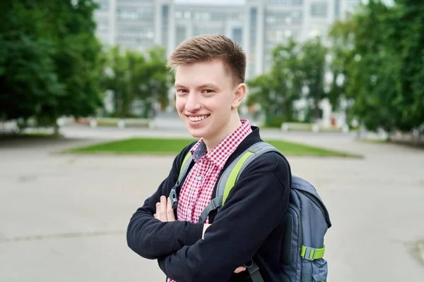 大学の屋外に対するバックパックと幸せな笑顔の若い学生の肖像画 コピースペース — ストック写真