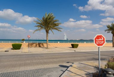 DUBAI, BAE - 24 Ocak 2017: Arka planda Dubai Ortadoğu, sokak yolu, palmiye ağacı, deniz ve lüks otel Burj Al Arab 'ın simgeleri 