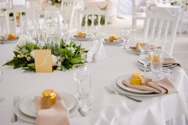 Boş misafir kartlı masa ayarları, peçeteli tabaklar ve çatal bıçak takımı, fotokopi alanı. Düğün resepsiyonunda. Restoranda yemek için servis edilen yuvarlak masa.