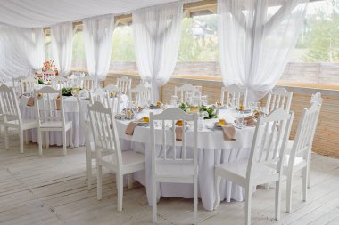 Boş misafir kartlı masa ayarları, peçeteli tabaklar ve çatal bıçak takımı, fotokopi alanı. Düğün resepsiyonunda. Restoranda yemek için servis edilen yuvarlak masa.