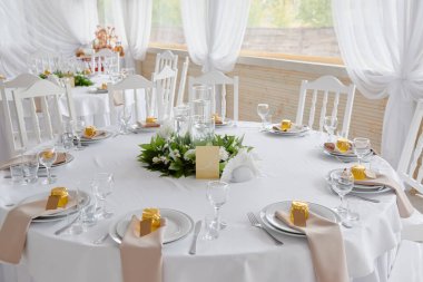 Boş misafir kartlı masa ayarları, peçeteli tabaklar ve çatal bıçak takımı, fotokopi alanı. Düğün resepsiyonunda. Restoranda yemek için servis edilen yuvarlak masa.