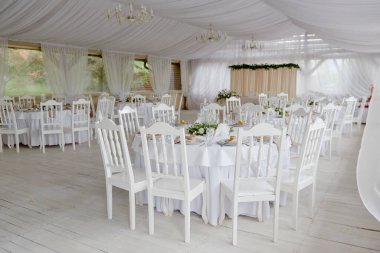 Boş misafir kartlı masa ayarları, peçeteli tabaklar ve çatal bıçak takımı, fotokopi alanı. Düğün resepsiyonunda. Restoranda yemek için servis edilen yuvarlak masa.