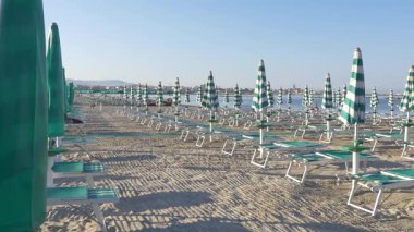 Boş plaj şemsiye ve şezlong dolu. Alghero Sardunya. 