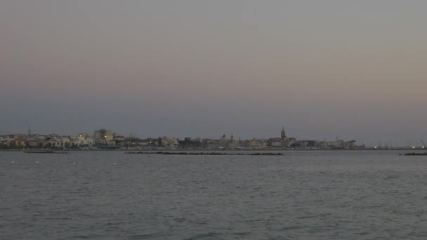 Puesta de sol en la playa de Alghero. Gente caminando por la playa . — Vídeo de stock