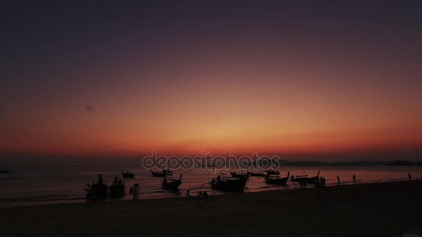 Захід сонця на пляжі тайський. Довгий хвіст човни, припарковані на пляжі — стокове відео