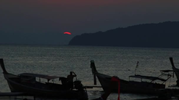 Закат на тайском пляже. Длинные хвостовые лодки припарковались на пляже — стоковое видео