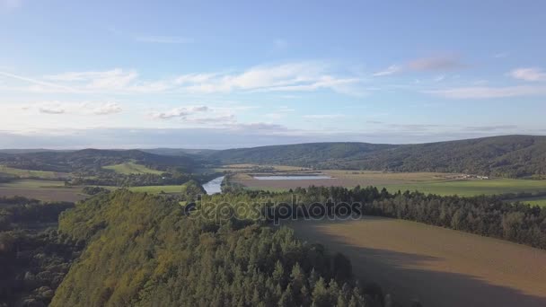 Vue aérienne des bois, des collines verdoyantes et des prairies .