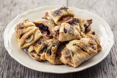 Ev yapımı tatlılar. Muz ve elma ve haşhaş tohumu ile rulo tatlı bir beyaz bir tabak