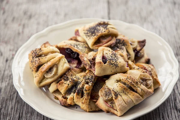 Hemlagad dessert. Dessert rulle med bananer, äpplen och vallmofrön en en vit platta Royaltyfria Stockfoton