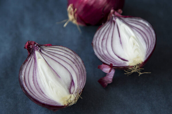 Onion and half an onion at a blue background