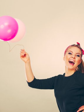 Balonlarla eğleniyor gülümseyen çılgın kız.
