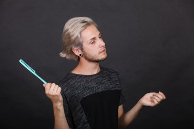 adam şık saç kesimi ile tarak elinde tutan