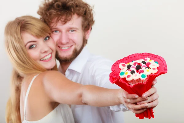 Glückliches Paar mit Süßigkeiten Strauß Blumen. Liebe. — Stockfoto