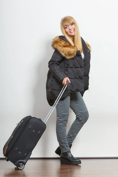 Glückliche junge Frau in warmer Jacke mit Koffer. — Stockfoto