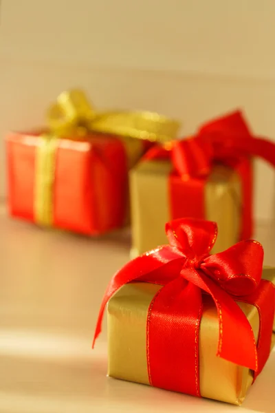 Kleine rote und goldene Schachteln mit Geschenken gebundenen Schleifen — Stockfoto