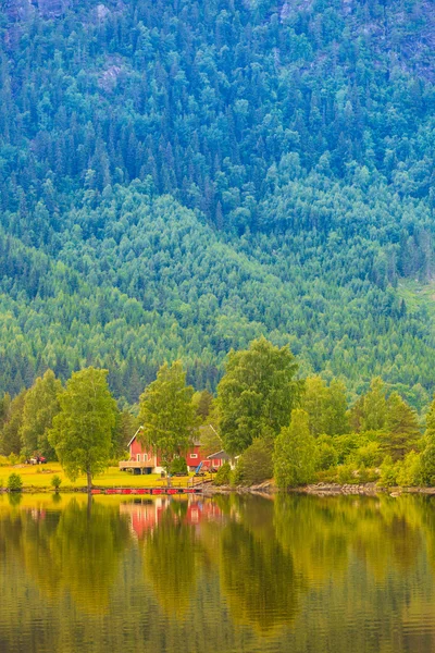 Casas de campo noruegas en las montañas a orillas del lago — Foto de Stock