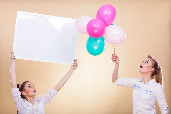 Duas meninas com placa em branco e balões — Fotografia de Stock