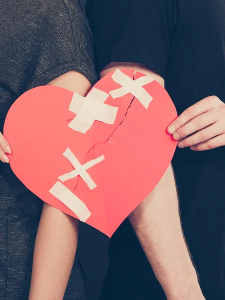 Woman and man hands holds broken heart. — Stock Photo, Image