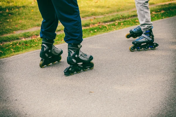 Teman di luar rumah bersenang-senang rollerblading bersama-sama . — Stok Foto