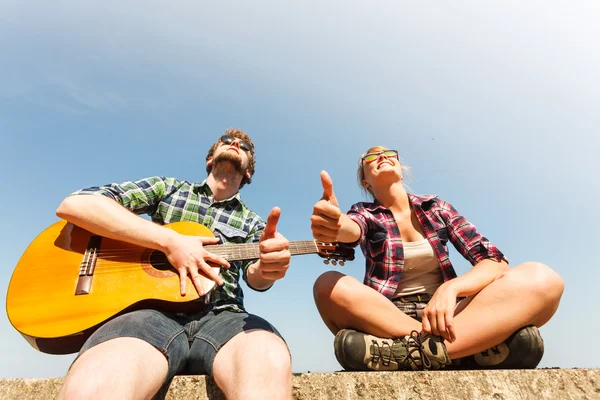 Joven hipster hombre con guitarra y mujer . — Foto de Stock