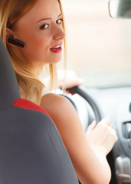 Mujer conduciendo coche con auriculares —  Fotos de Stock