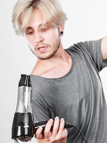 Joven hombre secando el cabello con secador de pelo — Foto de Stock