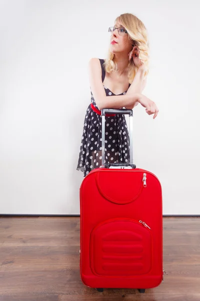 Woman pulling heavy red travel bag — Stock Photo, Image