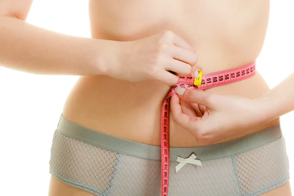Mulher em lingerie medindo sua cintura com fita métrica . — Fotografia de Stock